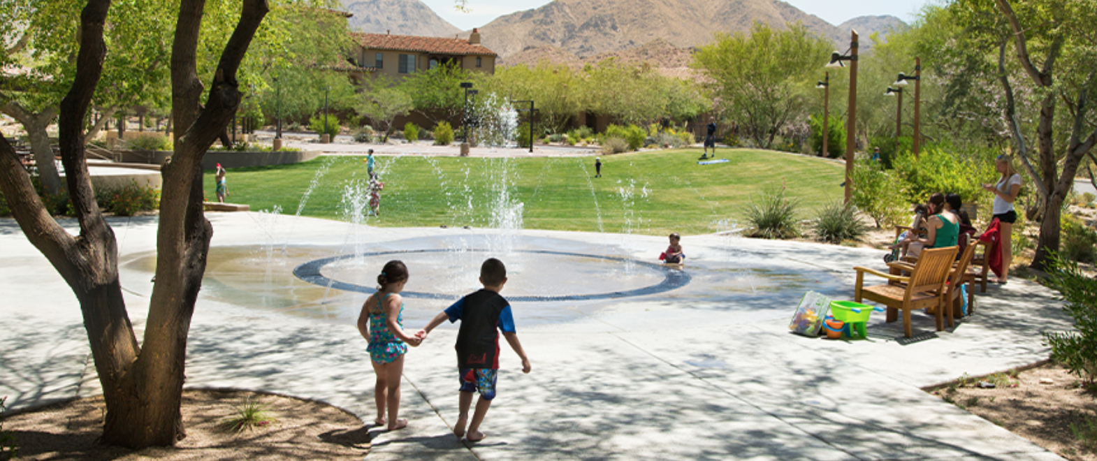 Homestead splash pad — children playing in fountains with McDowell mountains in the distance