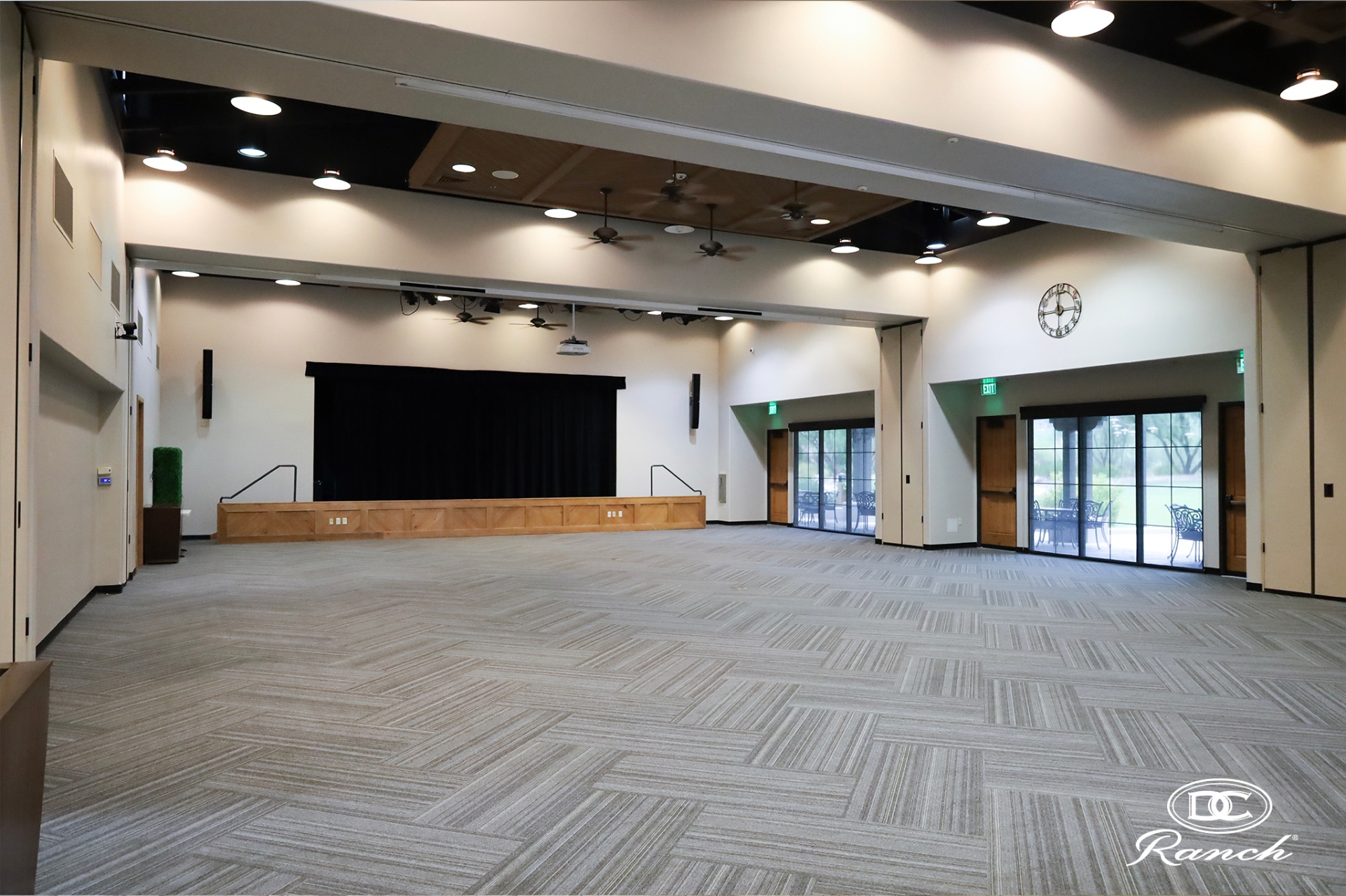 Homestead Grand Hall — existing multi-purpose room with operable wall panels, stage, and patio doors
