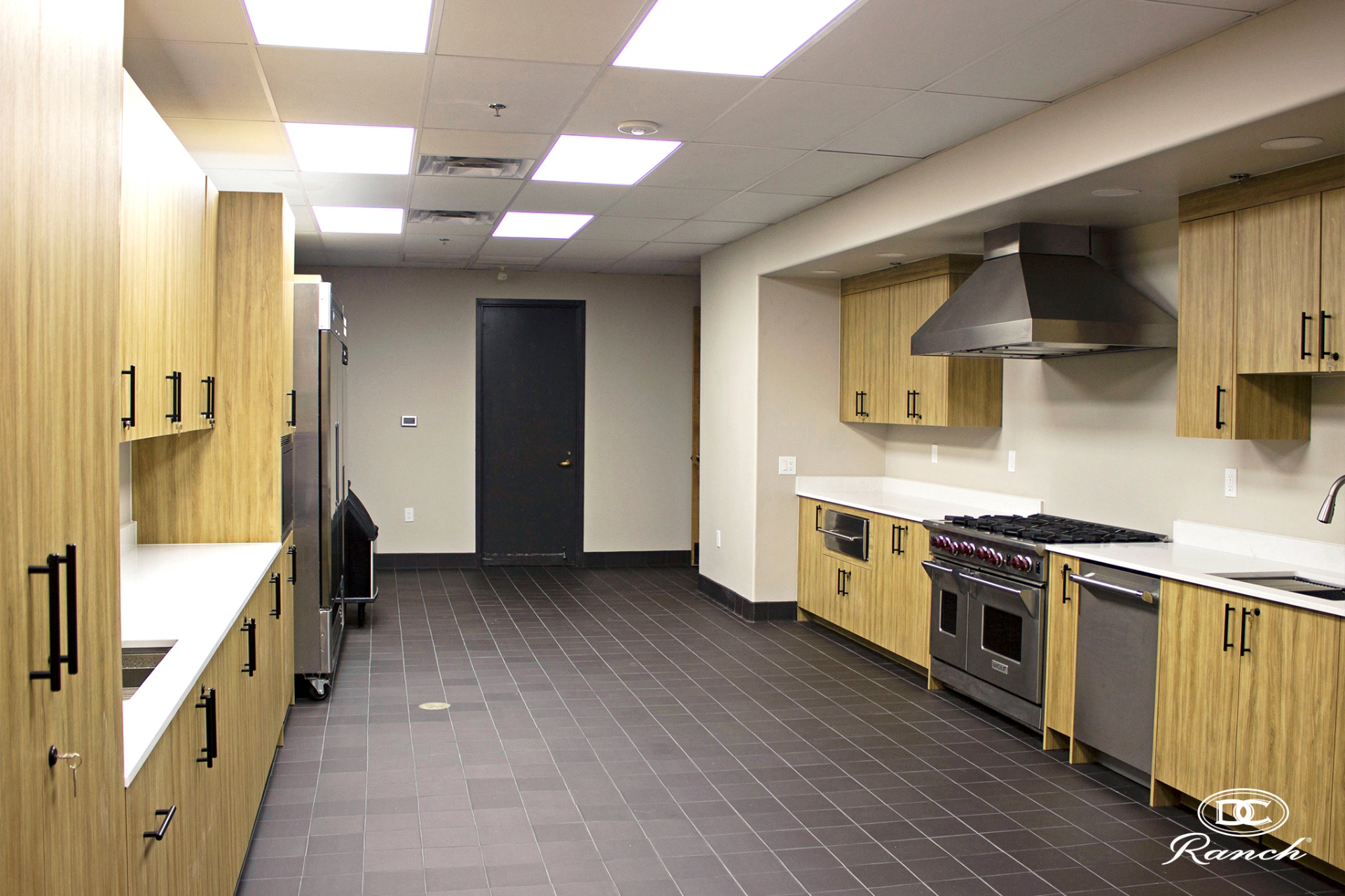 Homestead catering kitchen — existing conditions with commercial range, stainless prep, tile floor